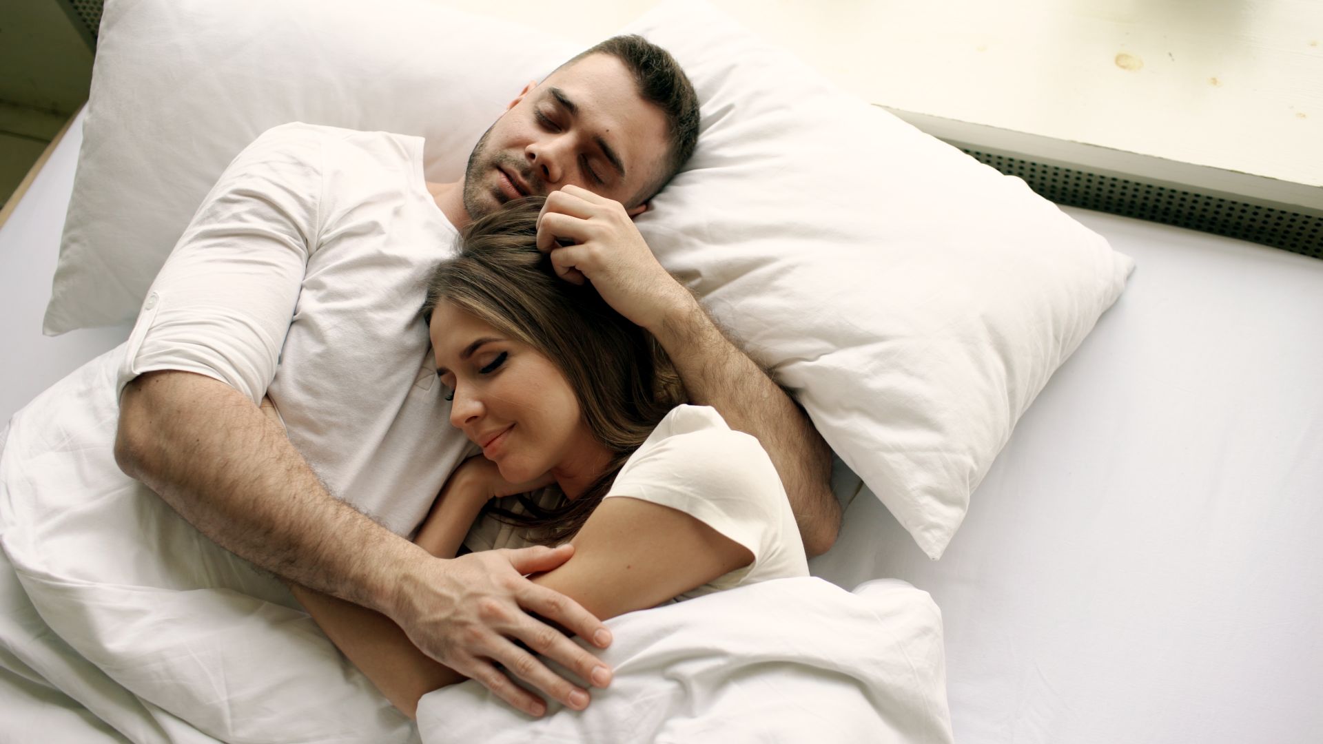 Couple sleeping comfortably in bed