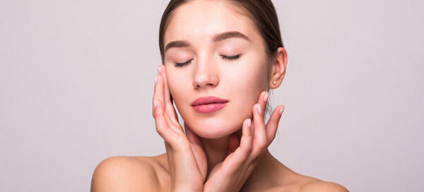 Smiling woman touching her face