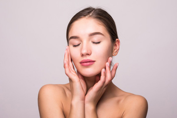 Smiling woman touching her face